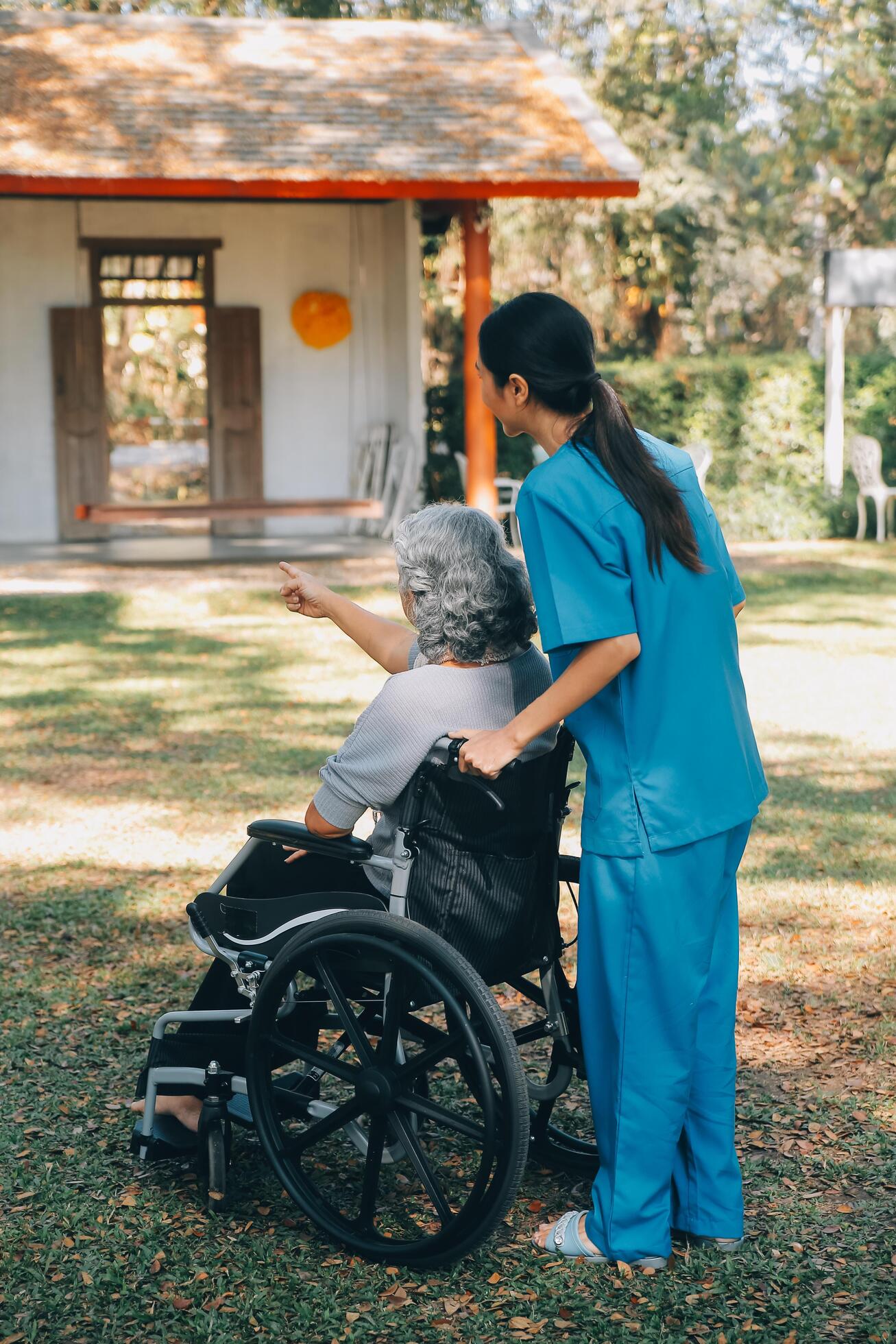 PIP Promise - young asian care helper with asia elderly woman on wheelchair relax together park outdoors to help and encourage and rest your mind with green nature help support yourself to learn to walk walker